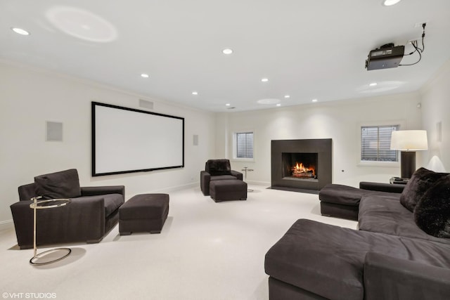 carpeted home theater with crown molding and a healthy amount of sunlight