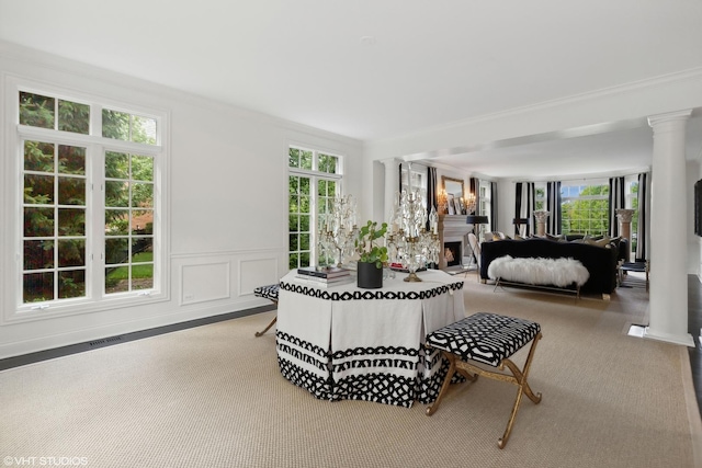 carpeted bedroom with multiple windows, ornamental molding, and decorative columns