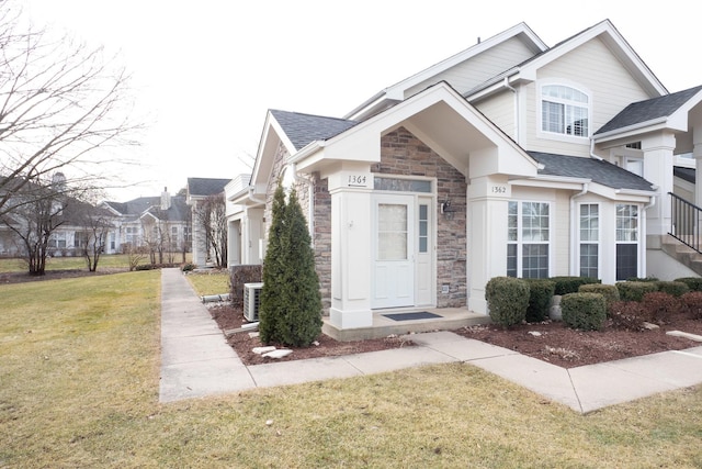 view of front of property featuring a front yard and central air condition unit