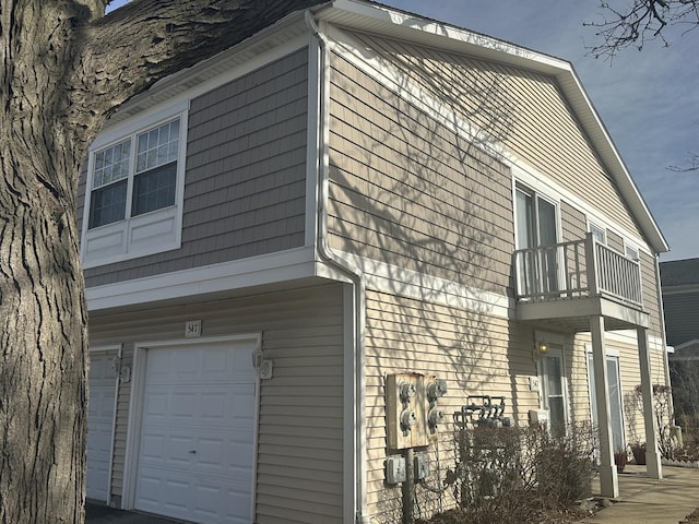 view of home's exterior featuring a garage and a balcony