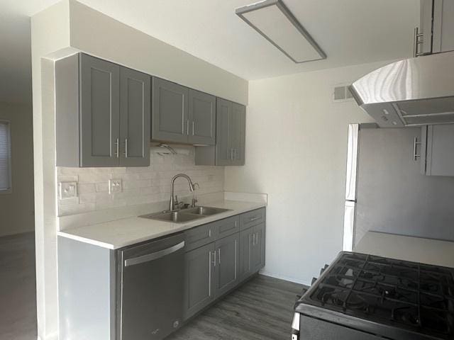 kitchen with a sink, stainless steel appliances, light countertops, and gray cabinetry