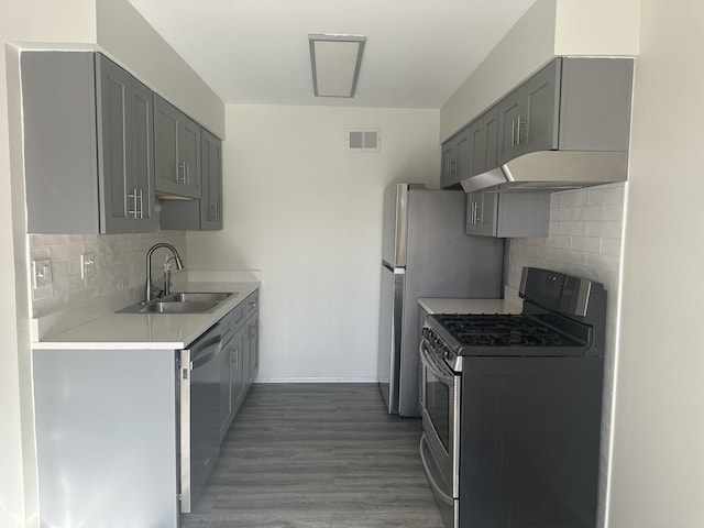 kitchen with gray cabinets, light countertops, a sink, and gas stove