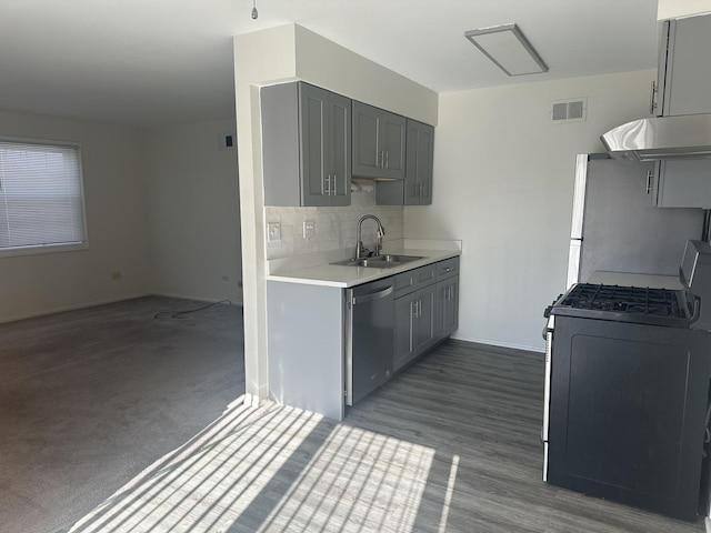 kitchen featuring stainless steel appliances, visible vents, light countertops, a sink, and under cabinet range hood