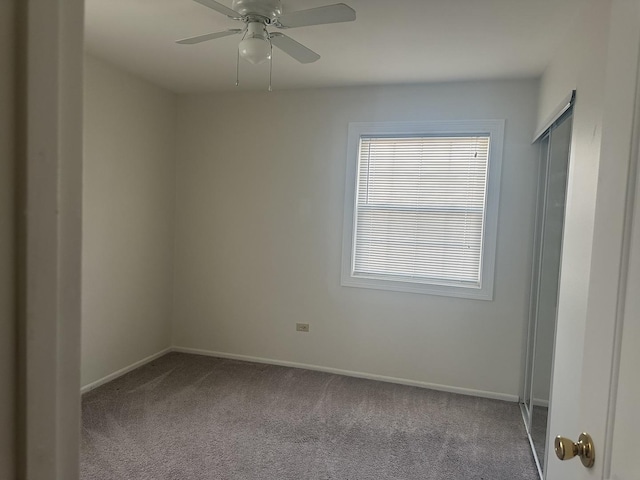 unfurnished room with a ceiling fan, light colored carpet, and baseboards