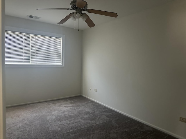 unfurnished room featuring ceiling fan, baseboards, visible vents, and dark colored carpet