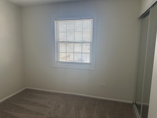 spare room featuring carpet flooring and baseboards