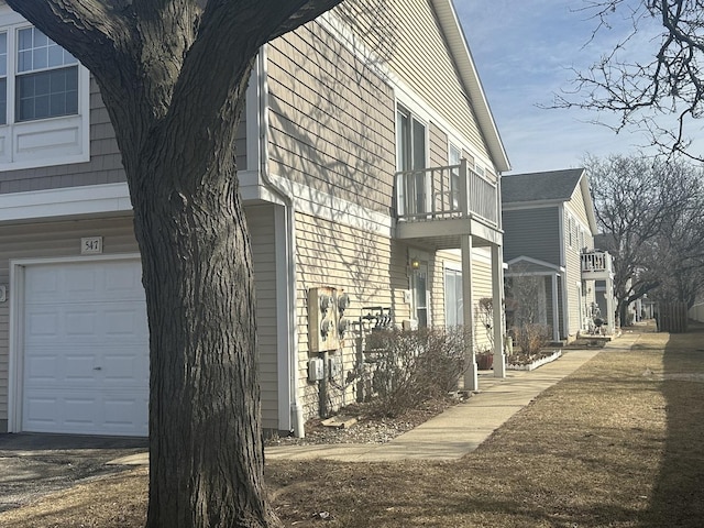 view of home's exterior featuring a garage and a balcony