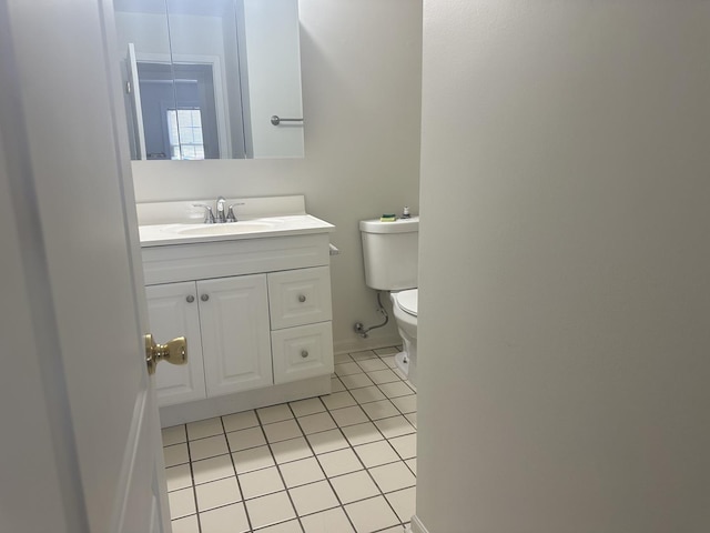 bathroom with toilet, vanity, and tile patterned floors