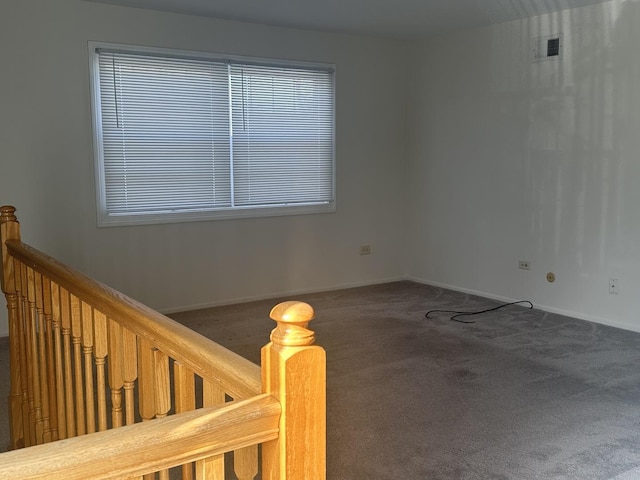 carpeted empty room with visible vents and baseboards