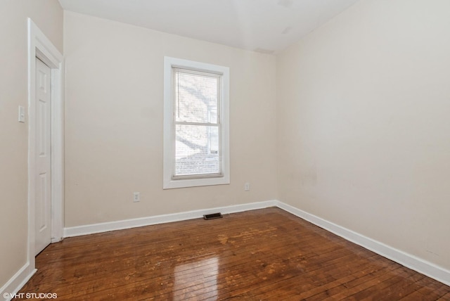 empty room with dark wood-style flooring and baseboards