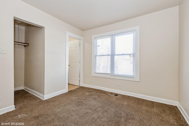 unfurnished bedroom featuring carpet, a closet, visible vents, and baseboards