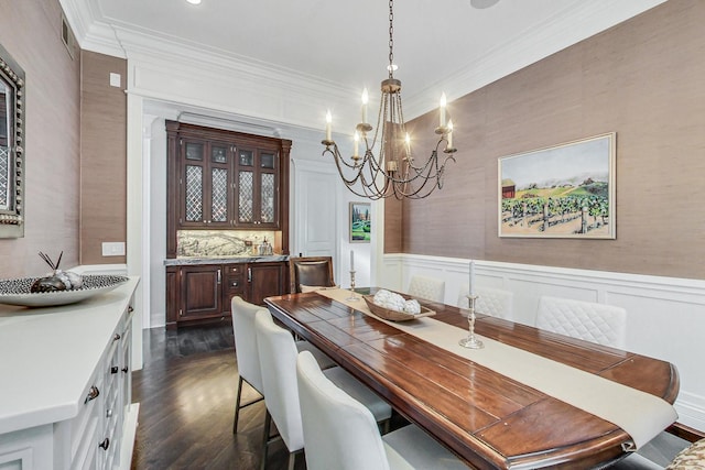 dining room with visible vents, a wainscoted wall, dark wood-style flooring, crown molding, and a notable chandelier