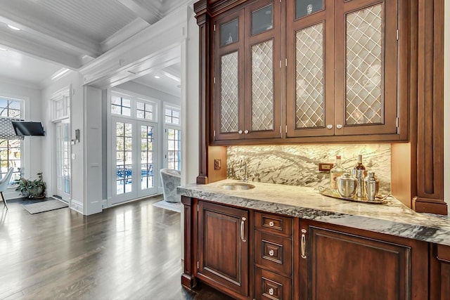 bar with baseboards, decorative backsplash, ornamental molding, dark wood-style flooring, and beamed ceiling