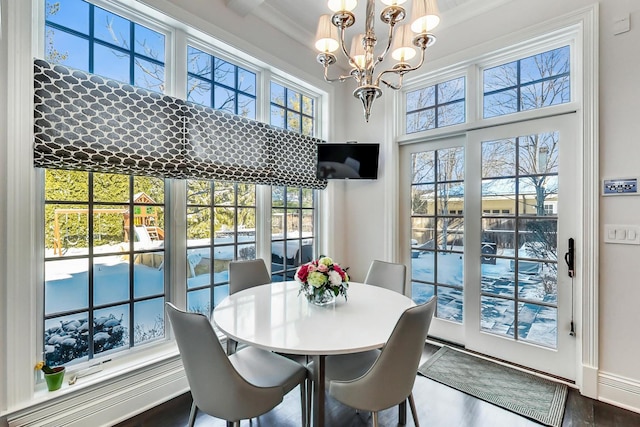 dining area featuring wood finished floors, a wealth of natural light, and a notable chandelier