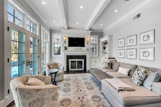 living area featuring french doors, beam ceiling, a fireplace, visible vents, and ornamental molding