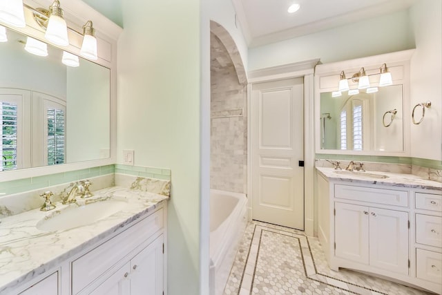 full bath featuring a tub to relax in, two vanities, a sink, and tile patterned floors