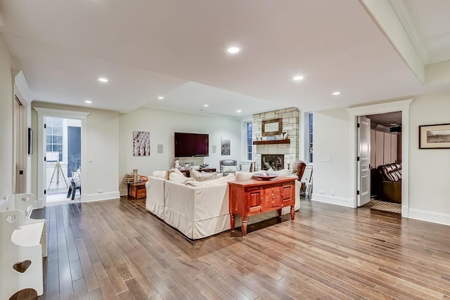 living room with a fireplace, baseboards, wood finished floors, and recessed lighting