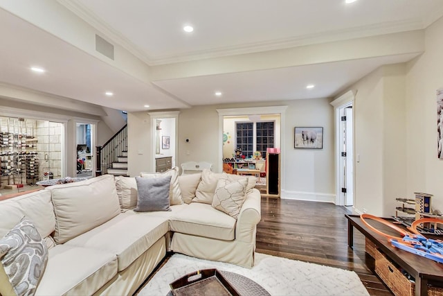 living area with dark wood-style floors, recessed lighting, ornamental molding, and stairs