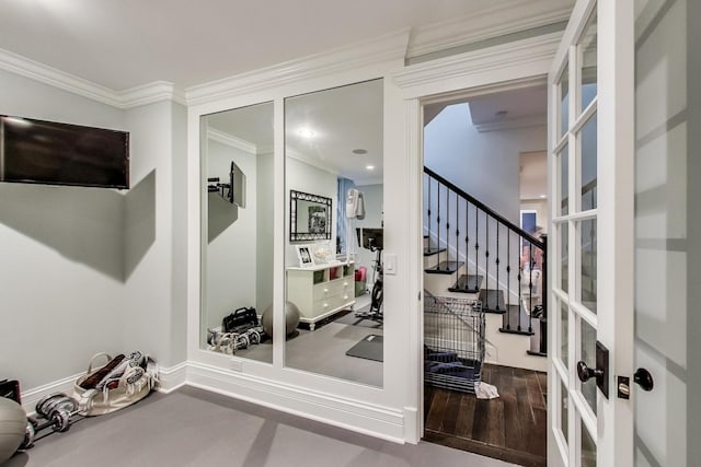 workout room featuring crown molding, baseboards, and wood finished floors