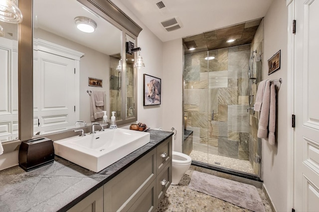 bathroom featuring toilet, vanity, visible vents, and a shower stall