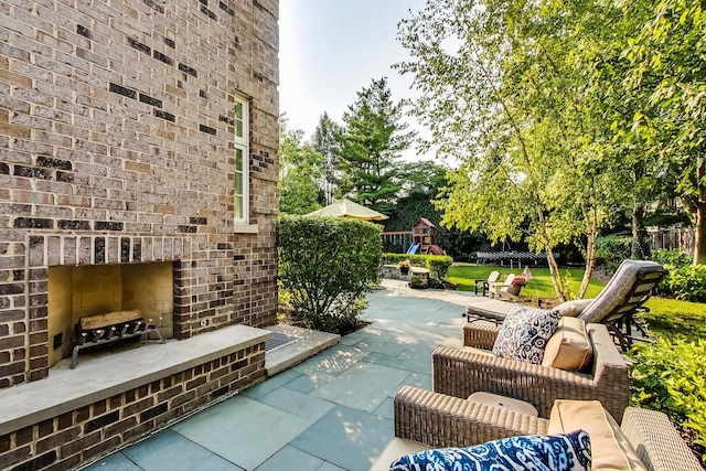 view of patio / terrace featuring an outdoor brick fireplace