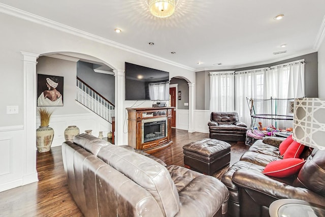 living room with dark hardwood / wood-style flooring, ornamental molding, and ornate columns