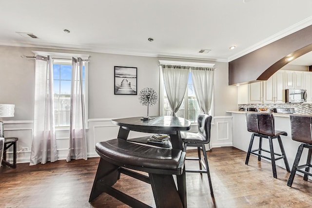 dining space with crown molding and hardwood / wood-style floors