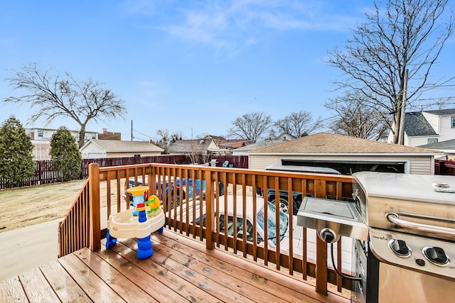 wooden deck with a pool and area for grilling