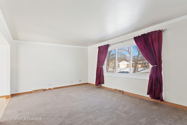 empty room featuring baseboards, carpet floors, visible vents, and crown molding