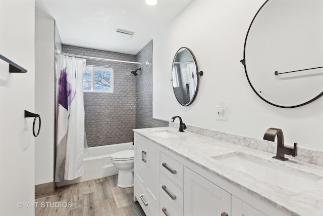 bathroom with double vanity, wood finished floors, a sink, and shower / bath combo with shower curtain