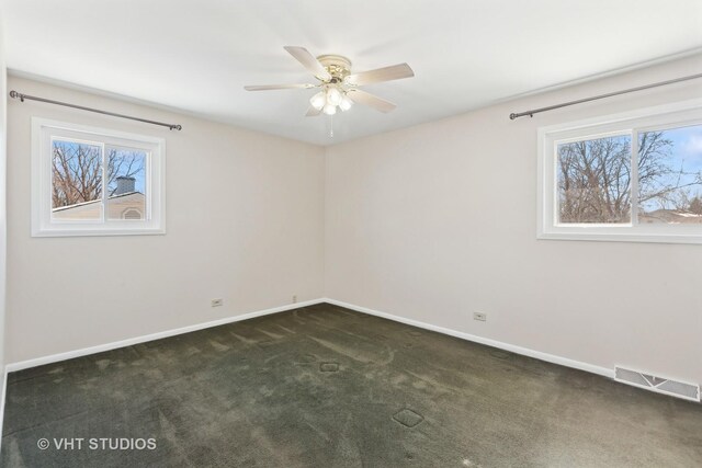 empty room featuring a ceiling fan, wood-type flooring, visible vents, and baseboards