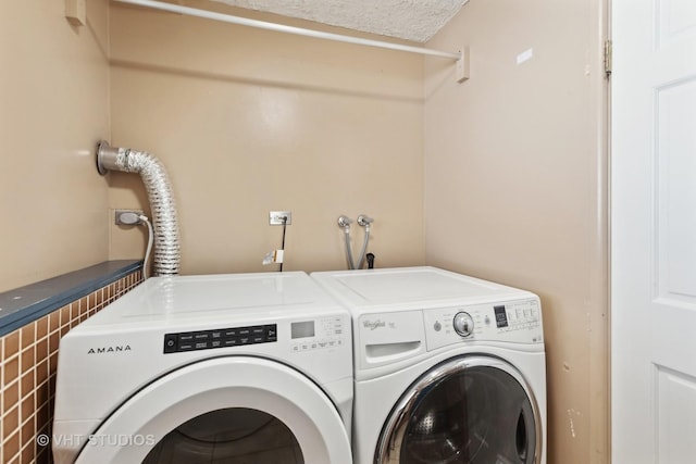 laundry area with a textured ceiling, laundry area, and washer and clothes dryer