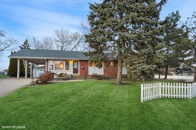 view of front of property with fence, decorative driveway, a front yard, a carport, and brick siding