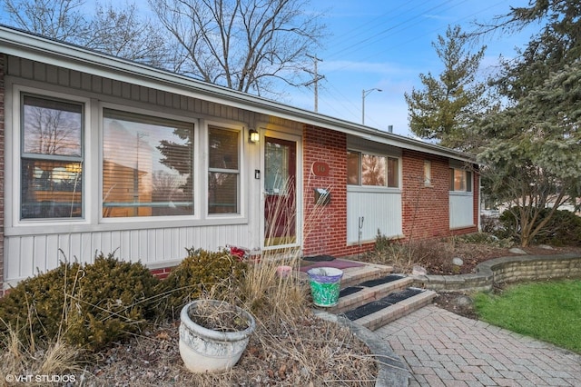 view of exterior entry with brick siding