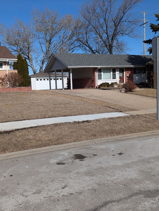 view of front facade featuring a carport, brick siding, driveway, and a shingled roof