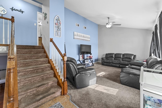 living room with lofted ceiling, ceiling fan, stairs, and light carpet