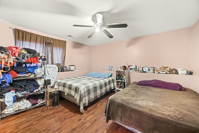 bedroom with visible vents, ceiling fan, and wood finished floors