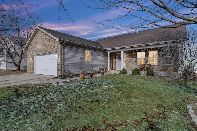 ranch-style home with a garage, a shingled roof, concrete driveway, a lawn, and brick siding