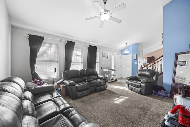 carpeted living room with ceiling fan, stairway, and vaulted ceiling