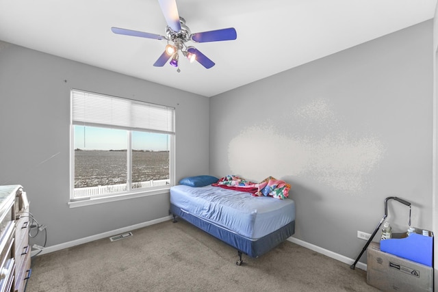 bedroom featuring light carpet, a ceiling fan, visible vents, and baseboards