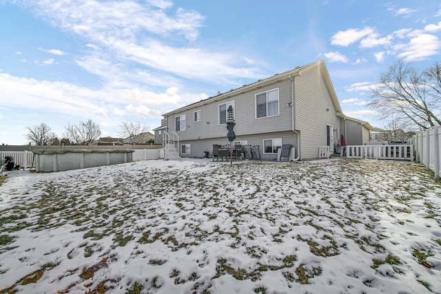 snow covered property featuring a fenced backyard