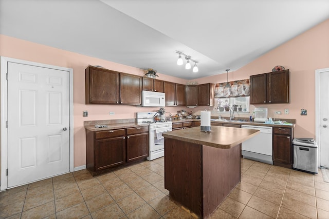 kitchen featuring a center island, light tile patterned flooring, a sink, dark brown cabinets, and white appliances