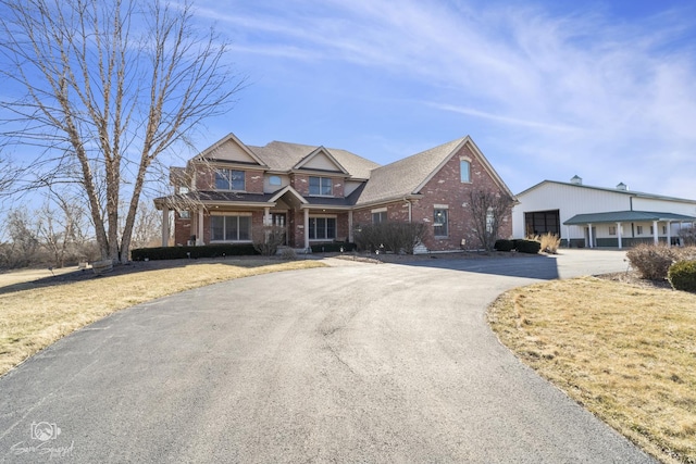 view of front of property featuring a detached garage and brick siding