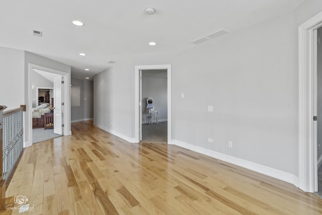 empty room featuring recessed lighting, visible vents, light wood-style flooring, and baseboards