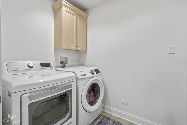 laundry area with independent washer and dryer, cabinet space, and baseboards