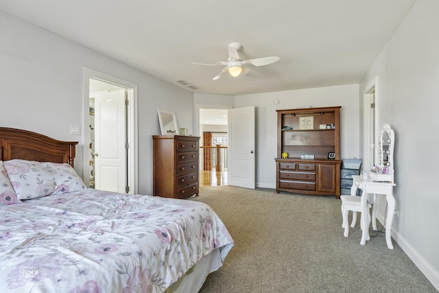 carpeted bedroom featuring a ceiling fan, visible vents, and baseboards