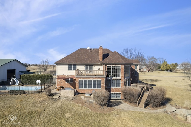 rear view of house featuring a patio, brick siding, a chimney, and a fenced in pool