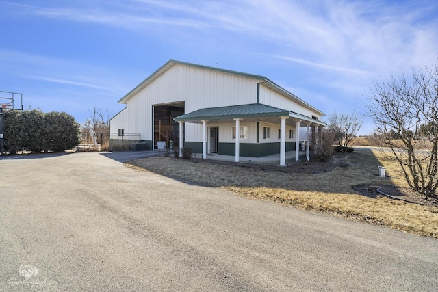 view of front of property featuring covered porch and metal roof