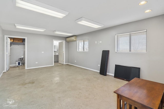 office area featuring a wall unit AC, baseboards, concrete flooring, and recessed lighting