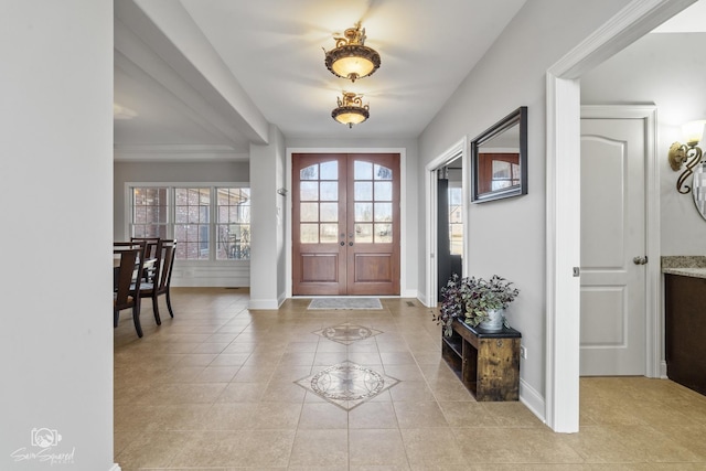 entryway with light tile patterned floors, baseboards, and french doors